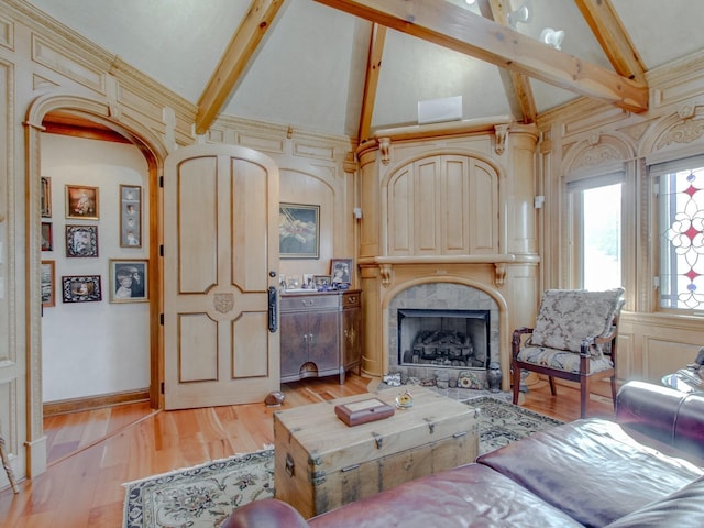 living room featuring beam ceiling, a fireplace, high vaulted ceiling, and light hardwood / wood-style floors