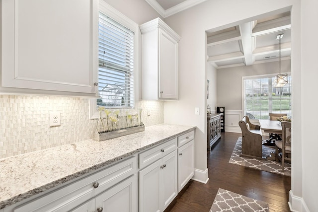 kitchen with light stone countertops, coffered ceiling, dark wood-type flooring, beam ceiling, and white cabinetry