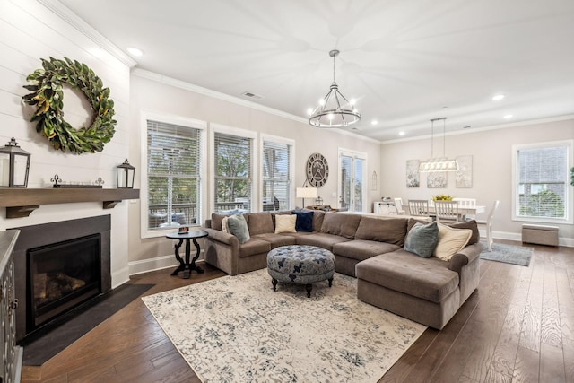 living room with a chandelier, dark wood-type flooring, and crown molding