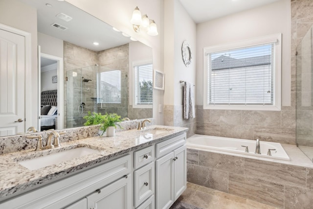 bathroom with vanity and shower with separate bathtub