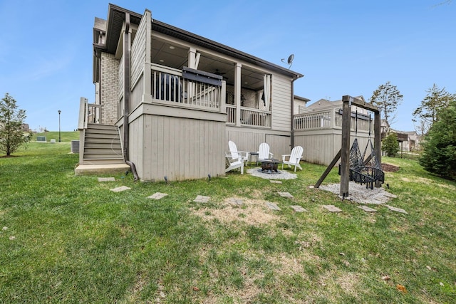 back of property featuring a yard, an outdoor fire pit, and ceiling fan