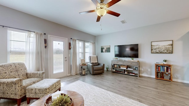 living room featuring ceiling fan and light hardwood / wood-style flooring