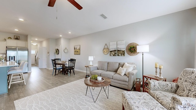 living room featuring light wood-type flooring and ceiling fan