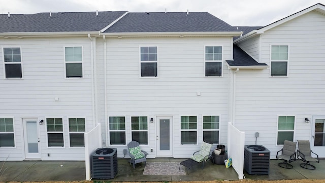 back of property with central air condition unit and a patio area