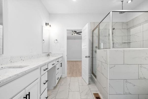 bathroom with vanity, ceiling fan, and a shower with shower door