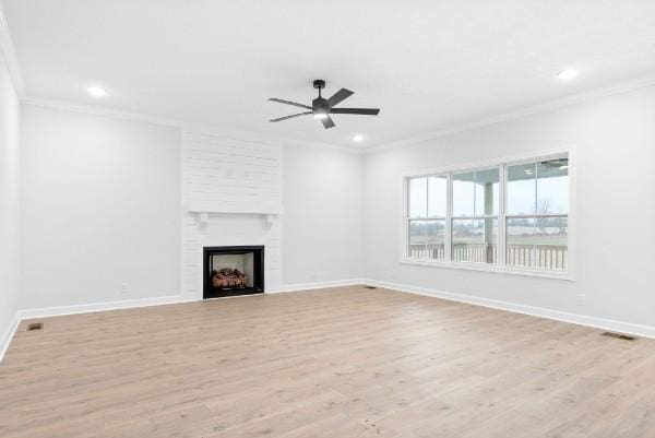 unfurnished living room with a fireplace, light wood-type flooring, ceiling fan, and ornamental molding