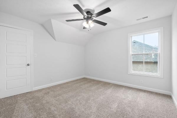 additional living space featuring carpet flooring, ceiling fan, and vaulted ceiling