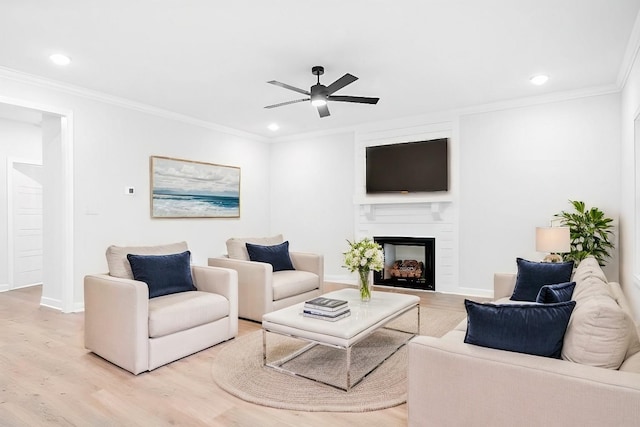 living room featuring light hardwood / wood-style flooring, ceiling fan, and ornamental molding