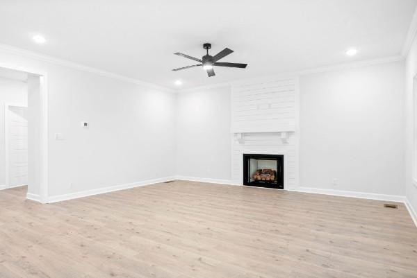 unfurnished living room with ceiling fan, a fireplace, ornamental molding, and light hardwood / wood-style flooring