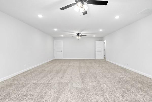 carpeted spare room with ceiling fan