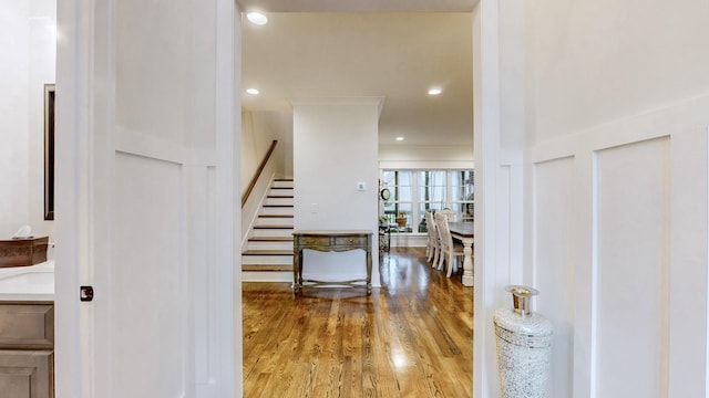 foyer entrance with crown molding and wood-type flooring