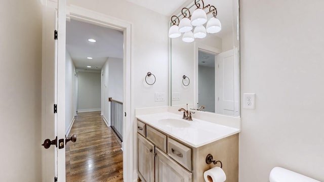 bathroom with hardwood / wood-style flooring, vanity, and toilet