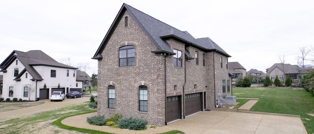 view of side of property featuring ac unit, a garage, and a yard