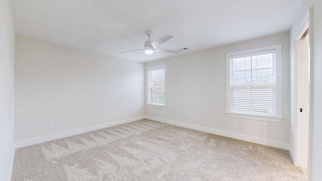 unfurnished room featuring light carpet, plenty of natural light, and ceiling fan