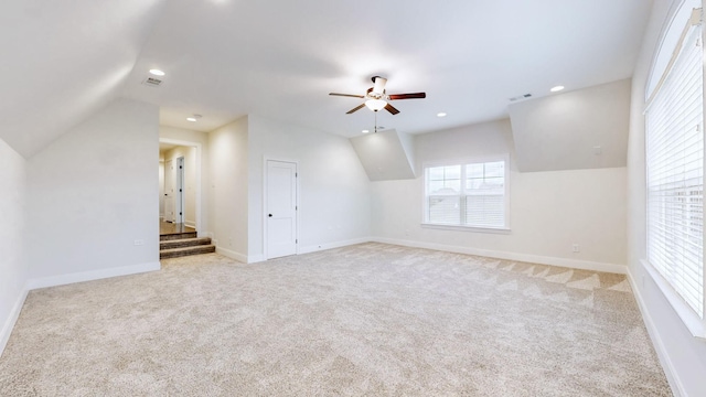 additional living space with ceiling fan, lofted ceiling, and light carpet