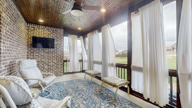 sunroom featuring ceiling fan and wood ceiling