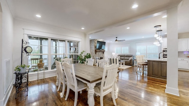 dining area with ceiling fan, dark hardwood / wood-style flooring, crown molding, and sink