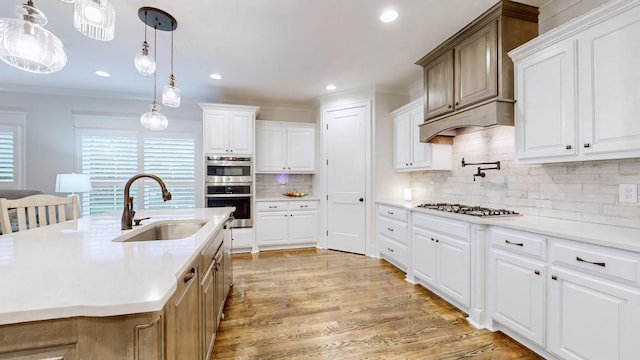 kitchen featuring white cabinetry, sink, hanging light fixtures, and tasteful backsplash