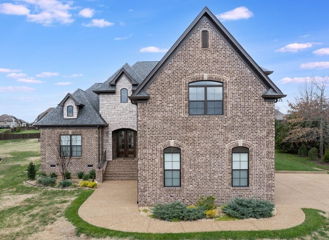 french country style house with a front yard and french doors