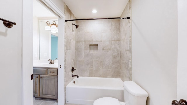 full bathroom featuring vanity, tiled shower / bath combo, and toilet