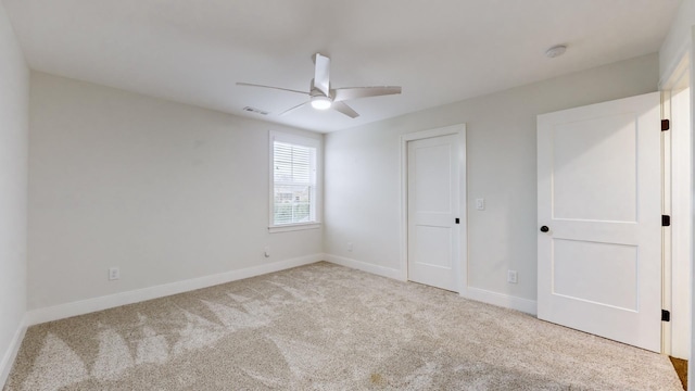 unfurnished bedroom featuring ceiling fan, a closet, and light colored carpet