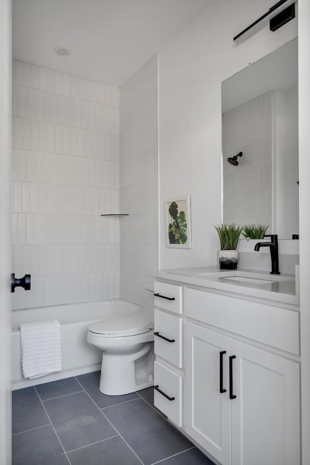 full bathroom featuring tile patterned floors, vanity, tiled shower / bath combo, and toilet