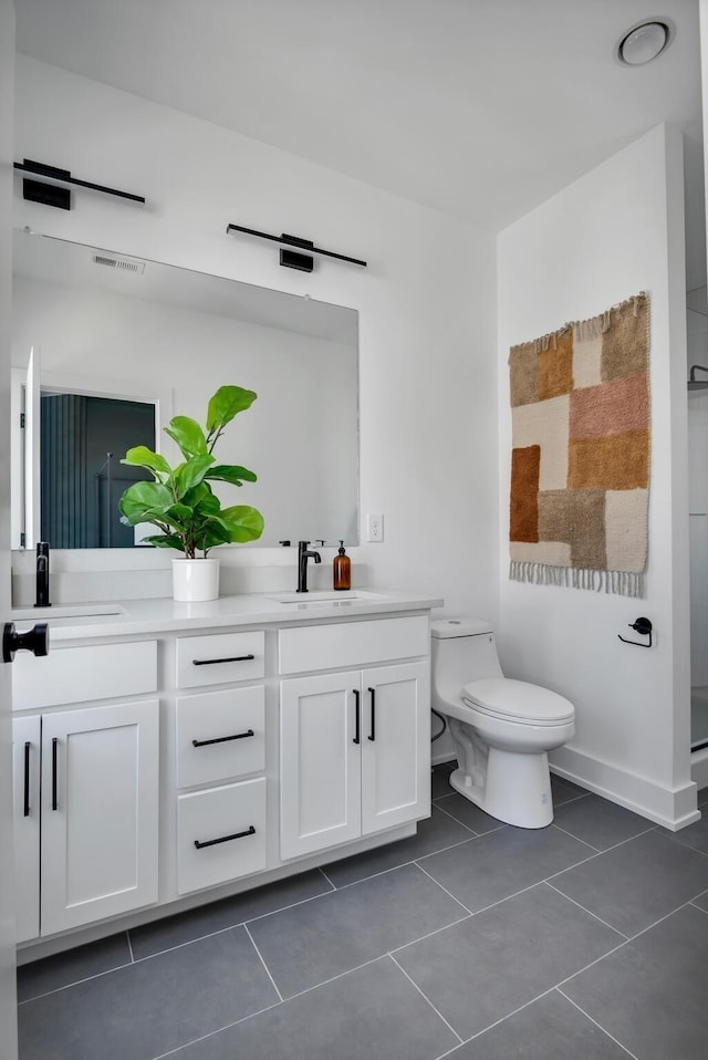 bathroom with tile patterned flooring, vanity, and toilet