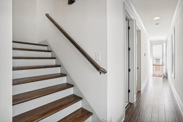 stairs with crown molding and hardwood / wood-style flooring