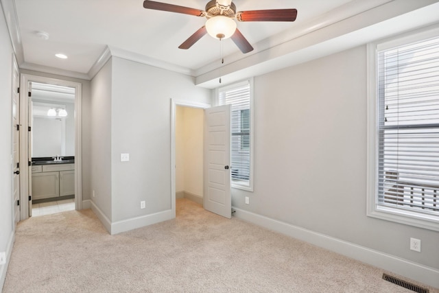 unfurnished bedroom with ceiling fan, crown molding, and light colored carpet