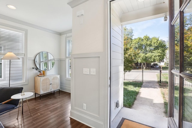 foyer entrance with dark hardwood / wood-style flooring and crown molding