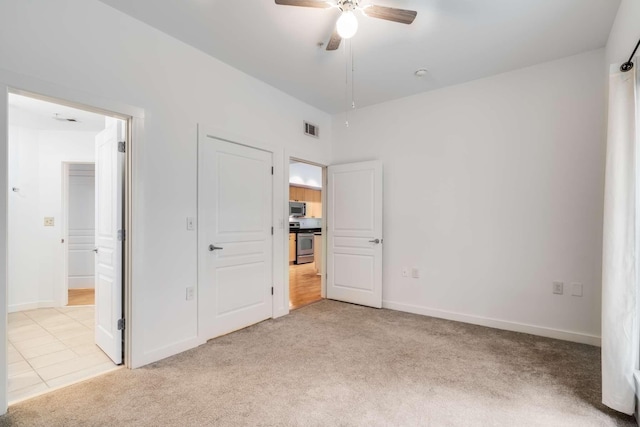 unfurnished bedroom with ceiling fan and light colored carpet