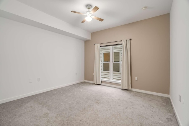 empty room featuring ceiling fan and light carpet