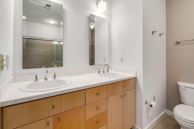 bathroom featuring tile patterned floors, vanity, toilet, and walk in shower