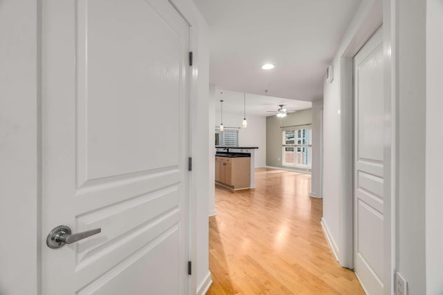 hallway featuring light wood-type flooring and sink