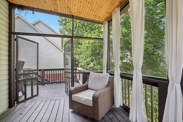 sunroom featuring vaulted ceiling, plenty of natural light, and wooden ceiling