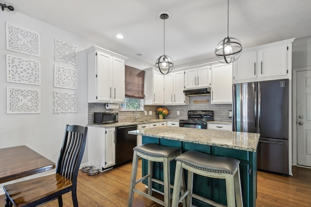 kitchen featuring sink, decorative light fixtures, white cabinetry, and black appliances