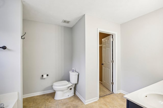 bathroom featuring vanity, a bath, and toilet