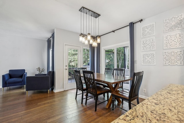 dining area with dark hardwood / wood-style flooring and a chandelier