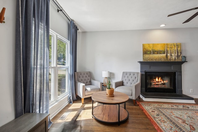 sitting room with hardwood / wood-style flooring and ceiling fan