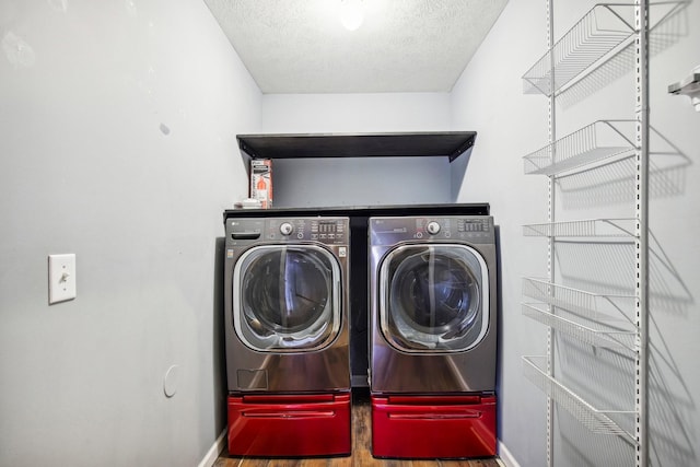 clothes washing area with washer and dryer and a textured ceiling