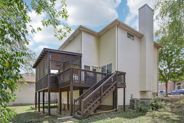 back of property with a wooden deck, cooling unit, and a sunroom