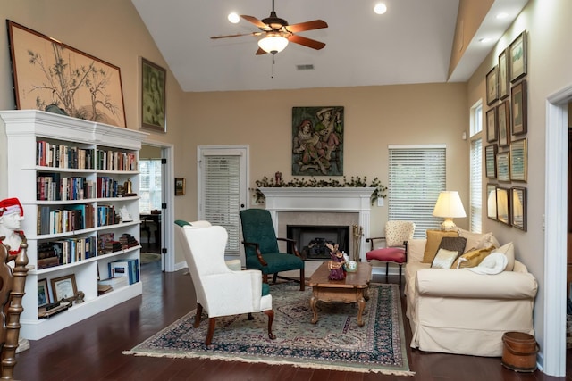 sitting room with high vaulted ceiling, ceiling fan, dark hardwood / wood-style flooring, and a tile fireplace