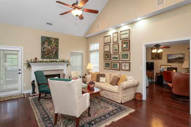 living room featuring a tile fireplace, ceiling fan, high vaulted ceiling, and dark wood-type flooring