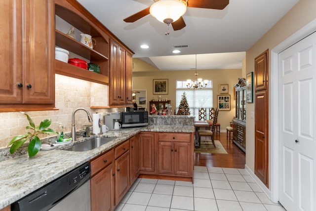 kitchen with sink, hanging light fixtures, stainless steel appliances, light stone counters, and kitchen peninsula