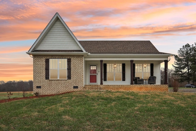 view of front facade with covered porch and a lawn