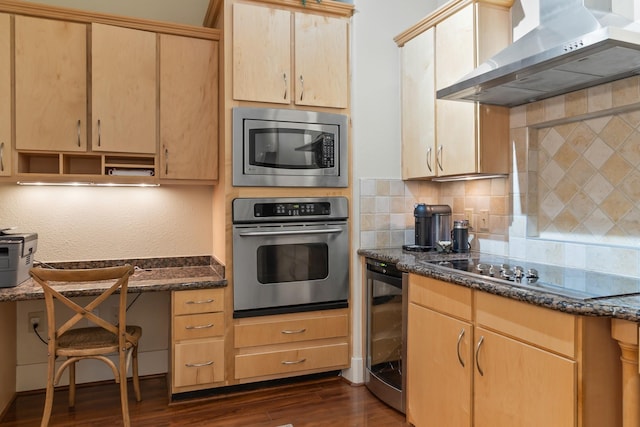 kitchen with appliances with stainless steel finishes, dark stone countertops, beverage cooler, and wall chimney exhaust hood