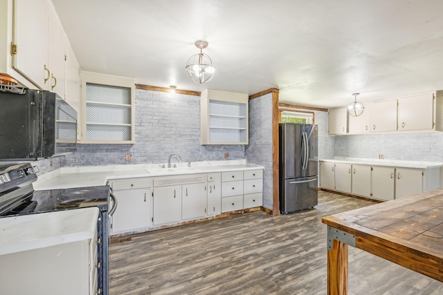 kitchen with range with electric cooktop, sink, decorative light fixtures, white cabinets, and stainless steel refrigerator