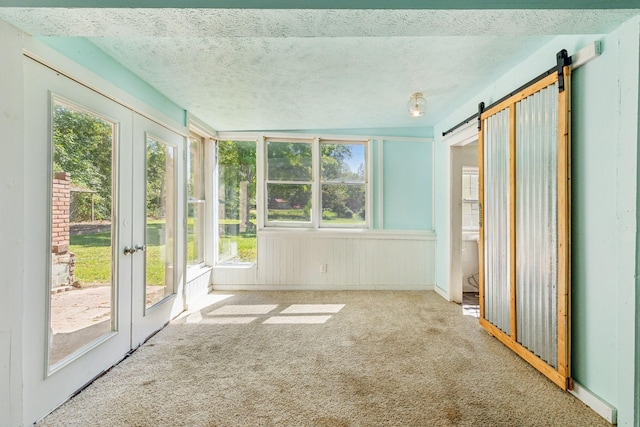 unfurnished sunroom featuring a barn door