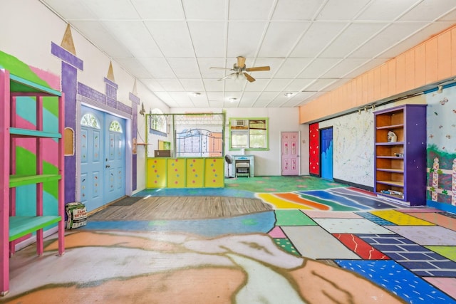 playroom featuring a paneled ceiling and ceiling fan