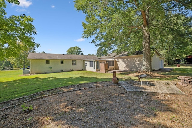 back of property featuring a garage and a lawn